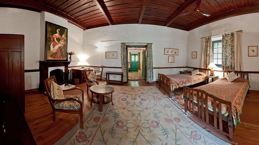 Alluringly decorated Kashmir Room with two separate single beds and a fireplace in the room - Ramgarh Bungalows, Nainital.