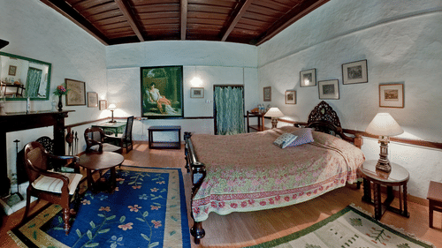 English Room with a fireplace opposite to the king size bed and features bedside lamp - Ramgarh Bungalows, Nainital.