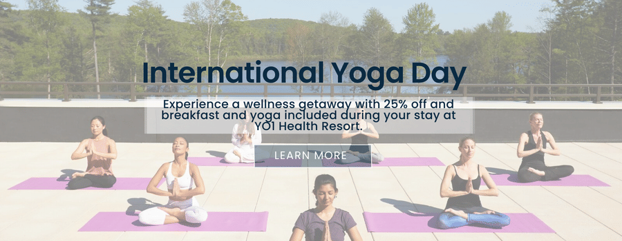 Banner for International Yoga Day at YO1 Longevity & Health Resorts, featuring participants practicing yoga outdoors with text inviting guests to embrace wellness and balance during their stay