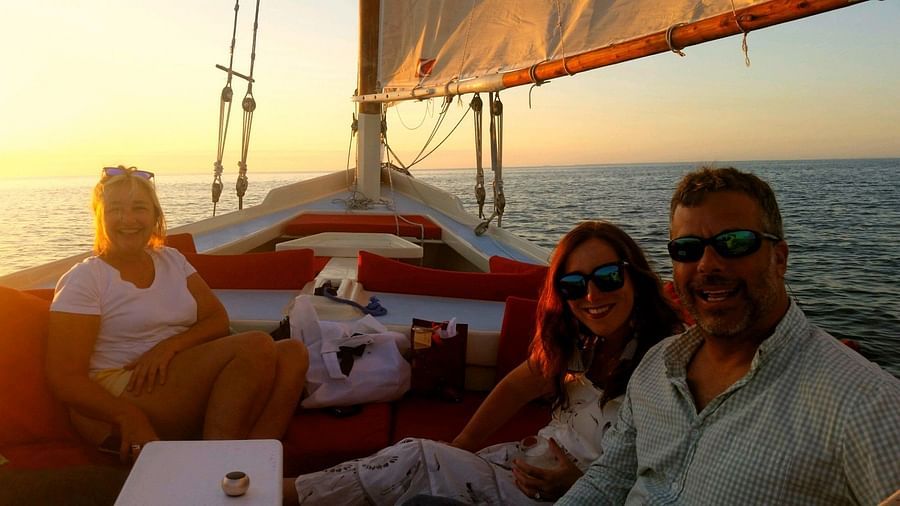 Three people sitting on a sailboat at sunset near Casa Morada, our resort in Islamorada.