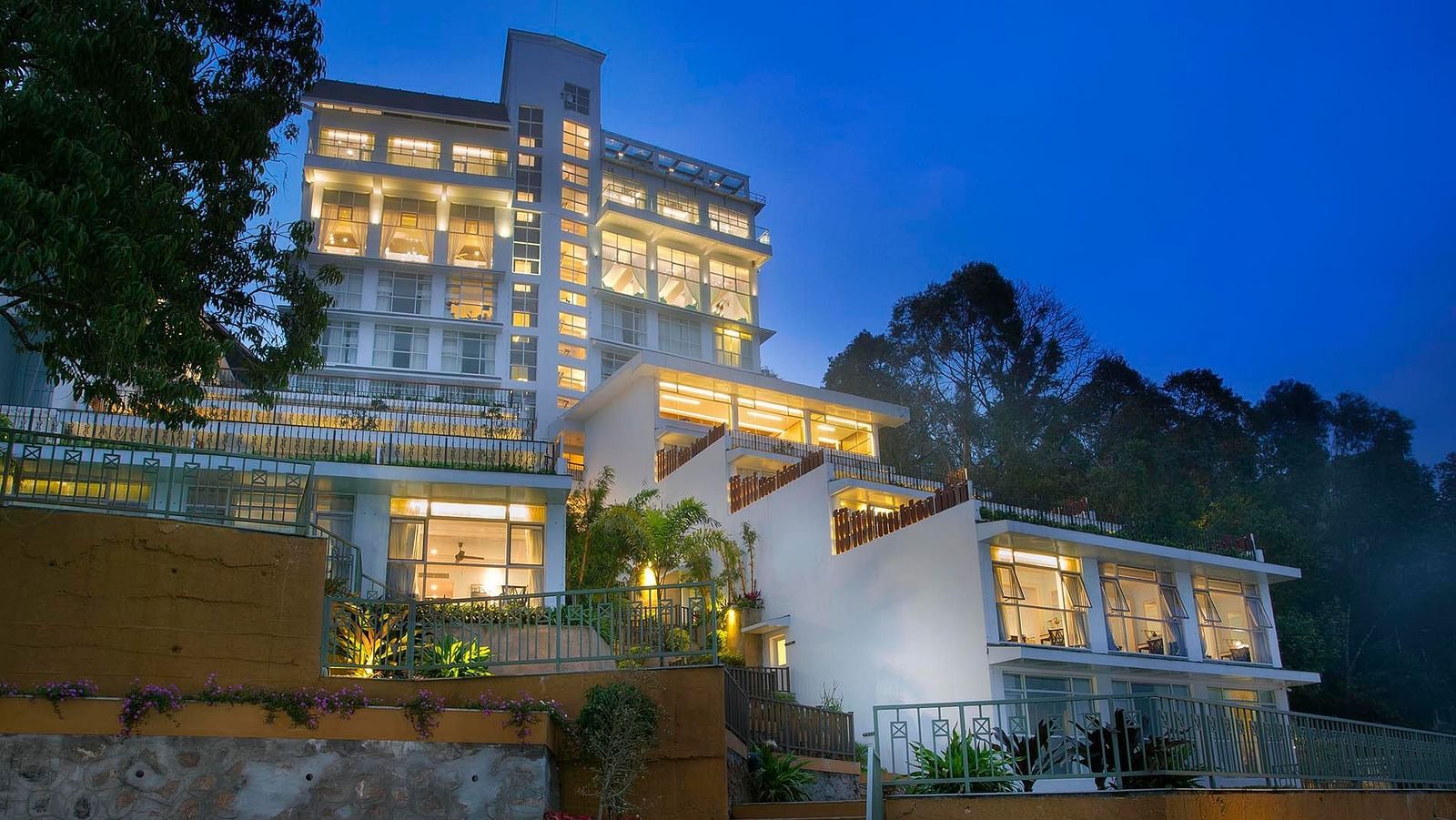 Facade view of Fragrant Nature Munnar illuminated at night.