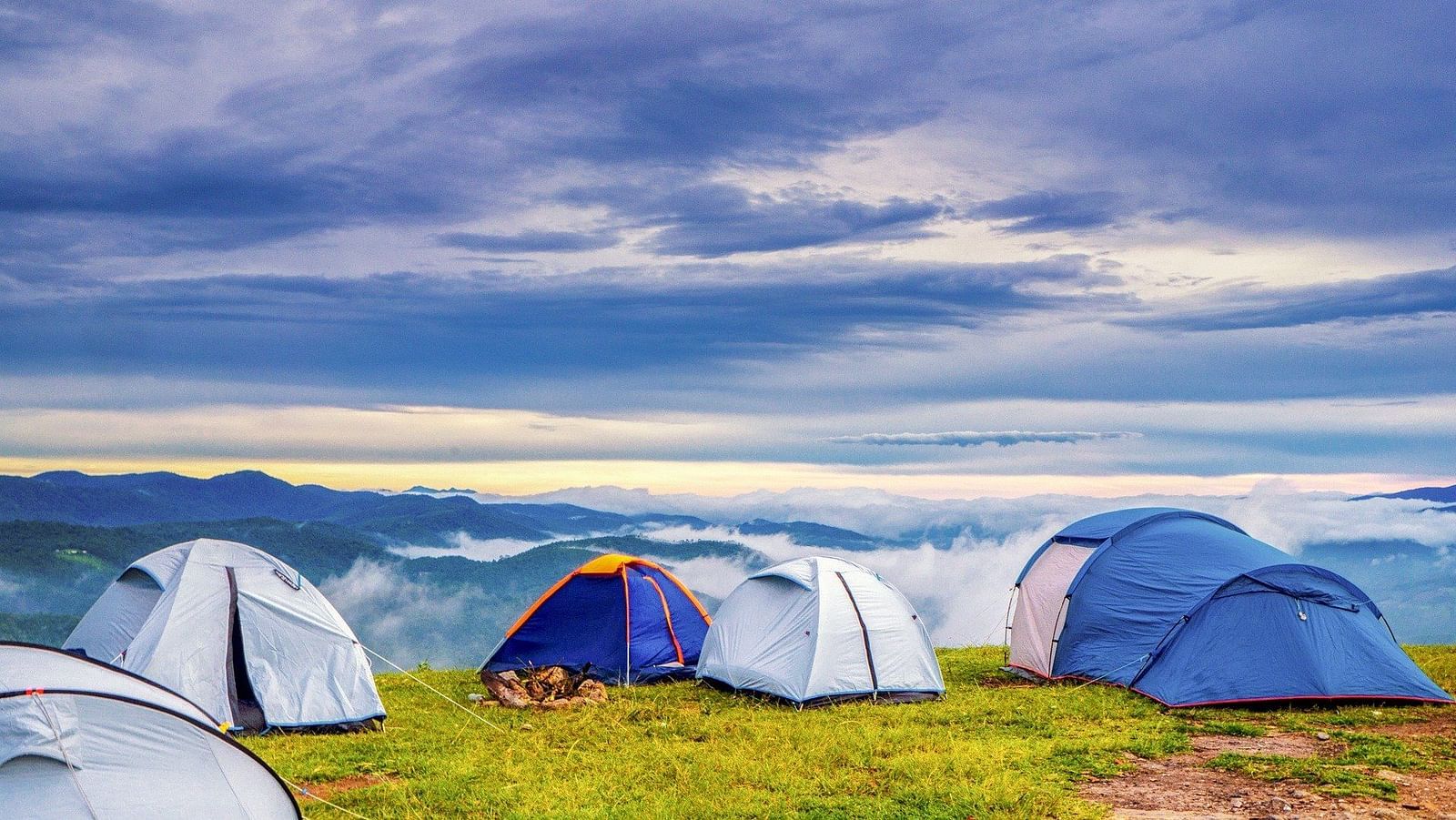 an image of dark clouds in the sky overlook the tents resting on the garden