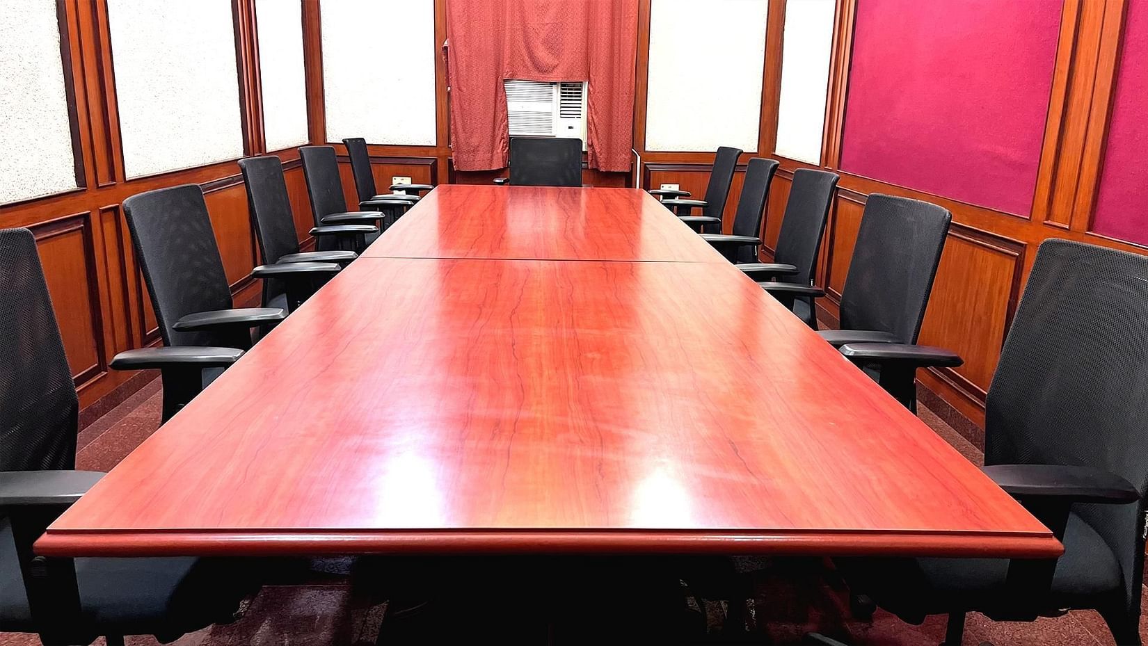 Boardroom featuring a U-shaped conference table neatly arranged with executive chairs, ideal for meetings and presentations