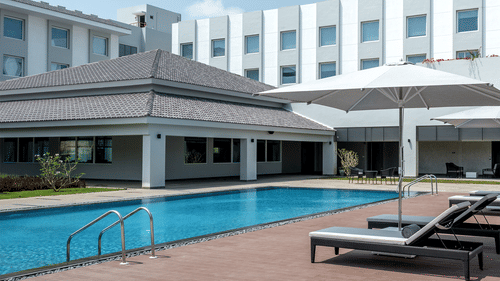 exterior of The Residency Towers Rameswaram with a swimming pool in front of it