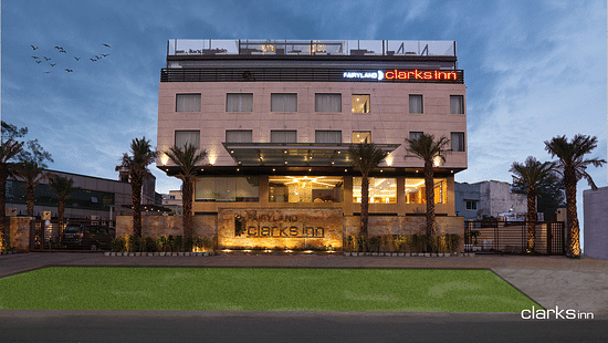 Facade of Fairyland Clarks Inn in Bhopal in an evening an a lawn in the front