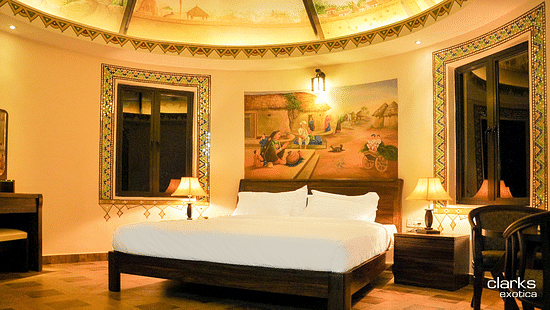 bedroom featuring a plush bed with a painting above the headboard and furniture arranged to the side