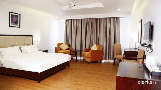 Bedroom featuring a double king-size bed and two couches along with a TV counter 