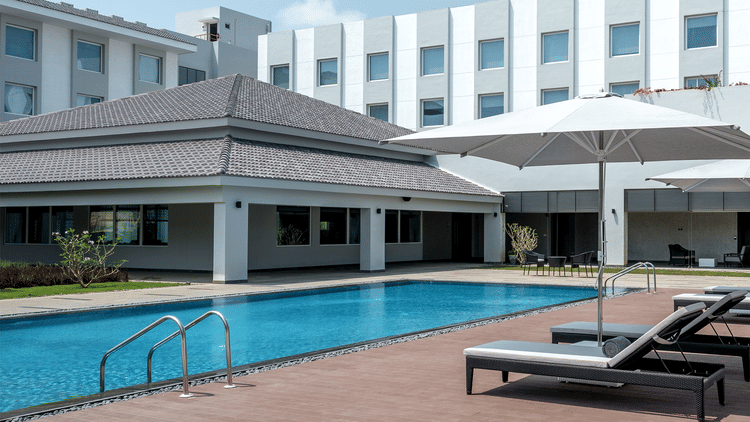 exterior of The Residency Towers Rameswaram with a swimming pool in front of it