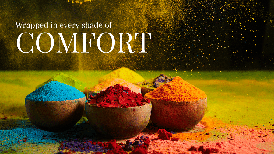 four bowls of colour powders of blue, red, orange and yellow on a vibrant floor as the text on the banner says - Wrapped in every shade of Comfort