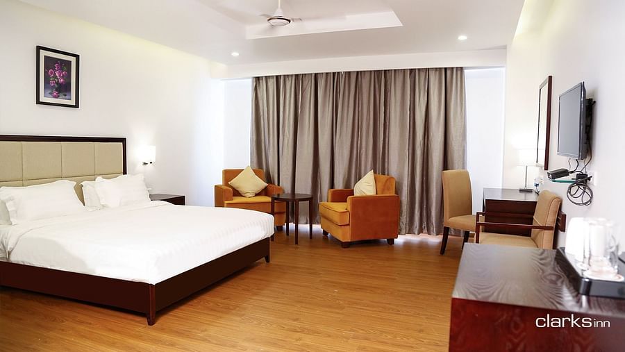 Bedroom featuring a double king-size bed and two couches along with a TV counter 