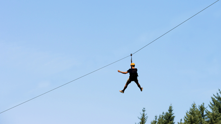 A thrill-seeker experiences an exciting zip-line ride high above the trees - District Gravity Adventure Park, Hyderabad