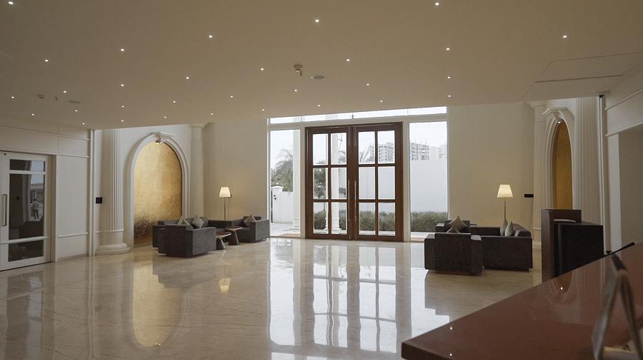 A spacious and elegantly designed hotel lobby of Pride Resort, Rajkot featuring a large doorways leading outdoors and inviting seating arrangements
