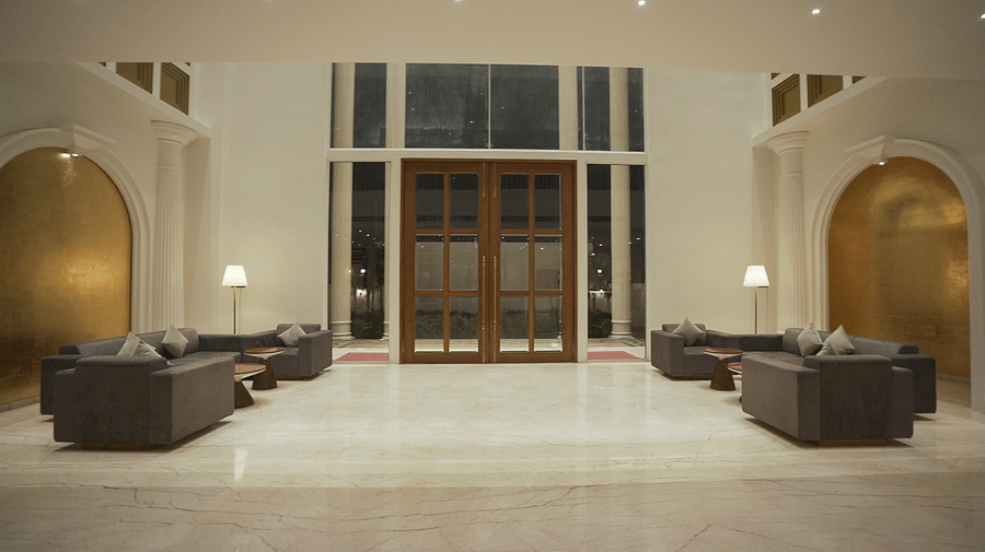 A a lavish hotel entrance or lobby of Pride Resort, Rajkot featuring high ceilings, expansive doorways, and ample seating, exuding grandeur