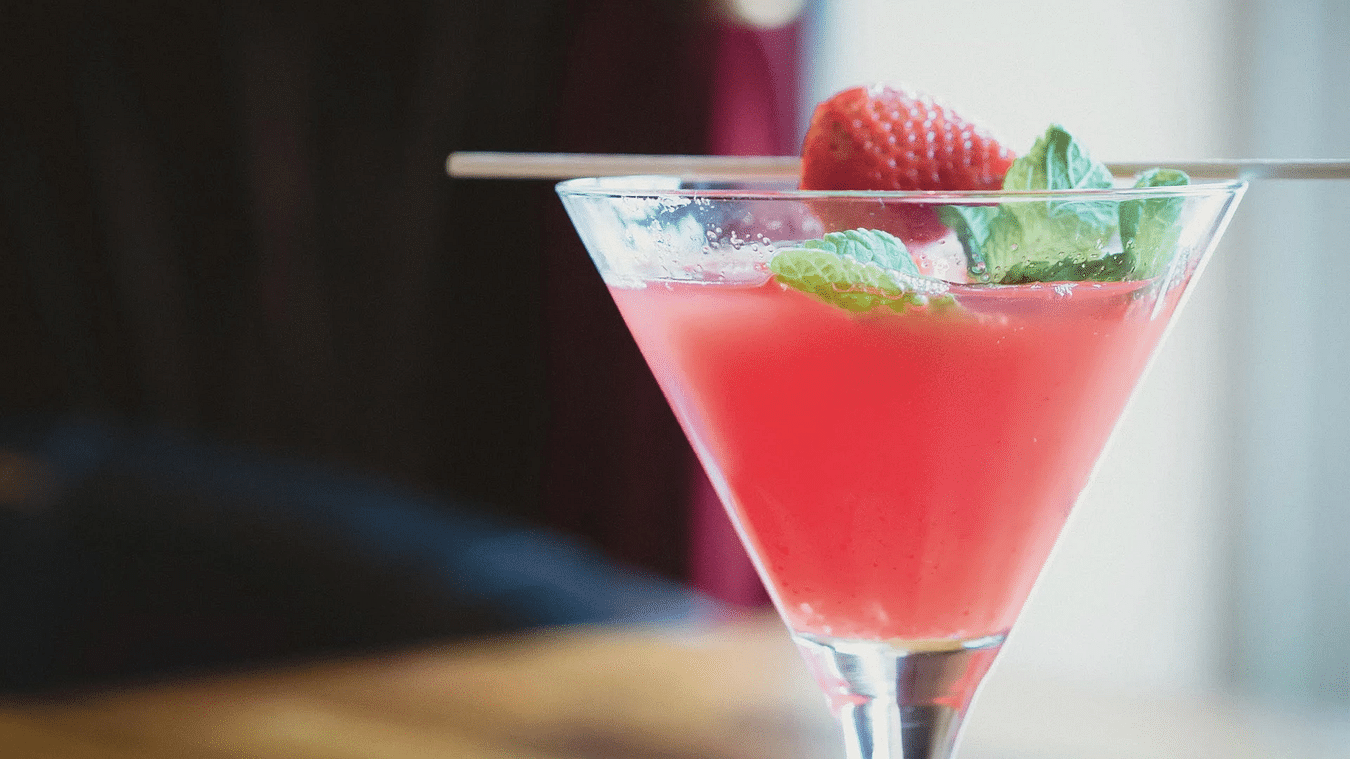 A refreshing cocktail garnished with a berry and mint leaves - S Hotel Kingston, Jamaica
