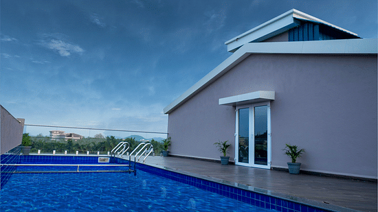 Pool and pool deck under cloudy sky