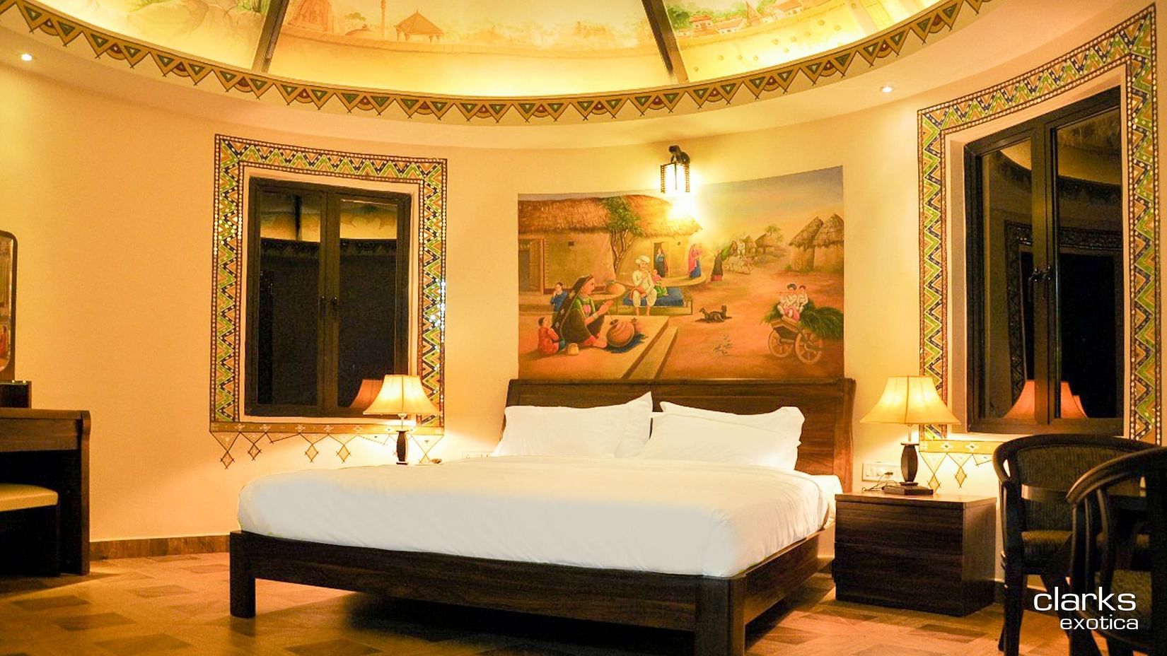 bedroom featuring a plush bed with a painting above the headboard and furniture arranged to the side