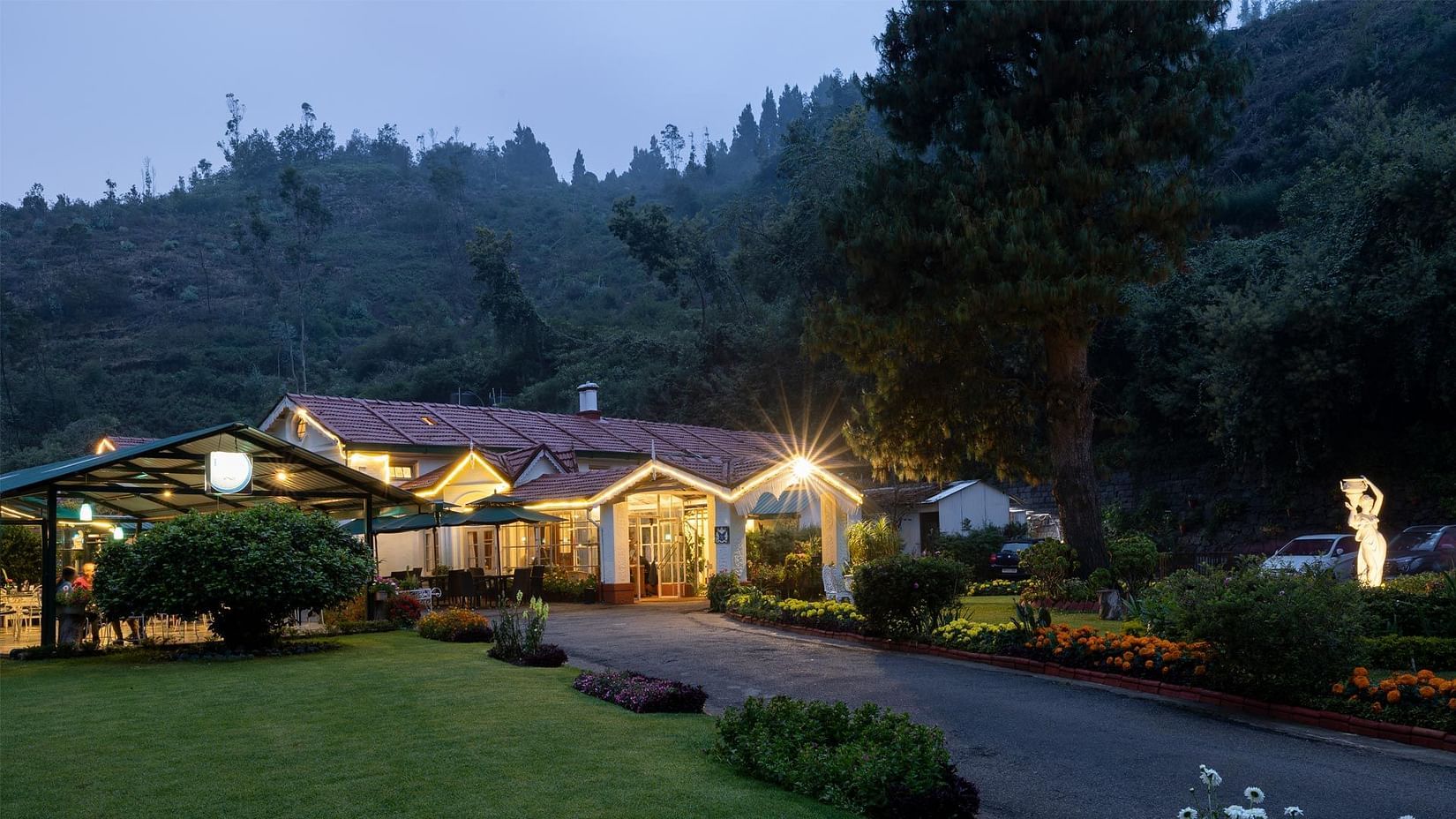An outdoor pic of the mansion that also shows the porch and the garden