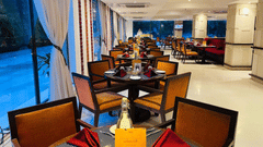 A view of a restaurant interior with multiple tables and chairs arranged for guests