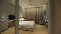 Superior Room featuring a comfortable double bed with pillows and cushions arranged over it at Pride Resort, Rajkot