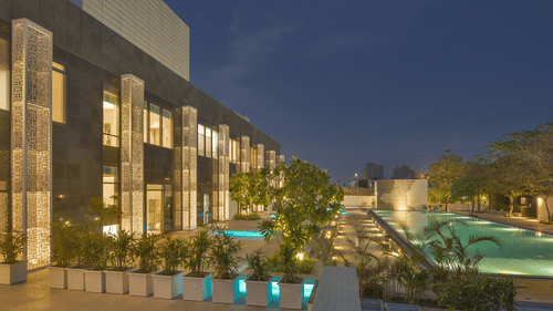 Exterior facade of Karma Lakelands in the night with the light on.