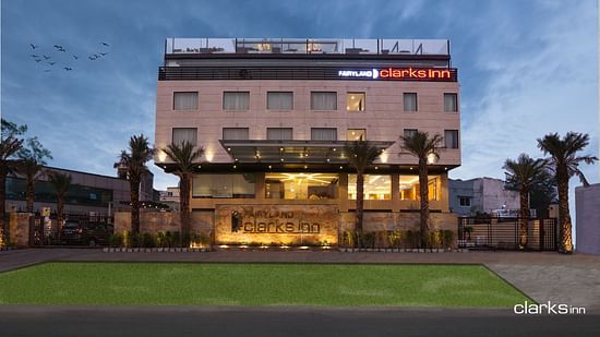Facade of Fairyland Clarks Inn in Bhopal in an evening an a lawn in the front