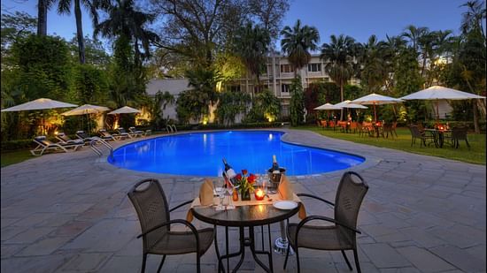 Clarks Varanasi - outdoor dining set up by the pool at nightttime 1