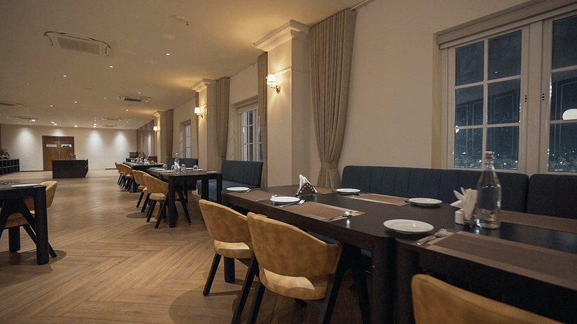 Side view shot of the restaurant at Pride Resort, Rajkot with navy blue coloured walls giving an elegant look