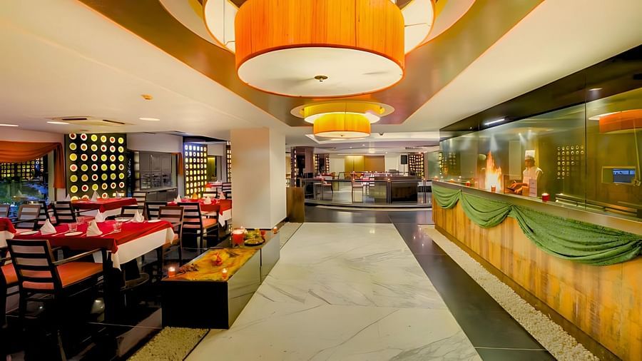 A spacious dining area at Pride Plaza Ahmedabad with tables set for guests.