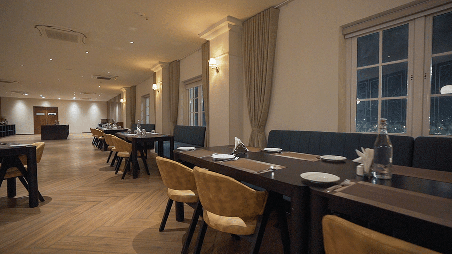 Side view shot of the restaurant at Pride Resort, Rajkot with navy blue coloured walls giving an elegant look