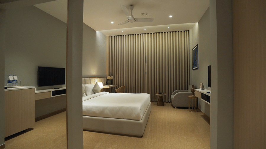 Overview shot of Superior Room featuring a comfortable double bed with pillows and cushions arranged over it - Pride Resort, Rajkot