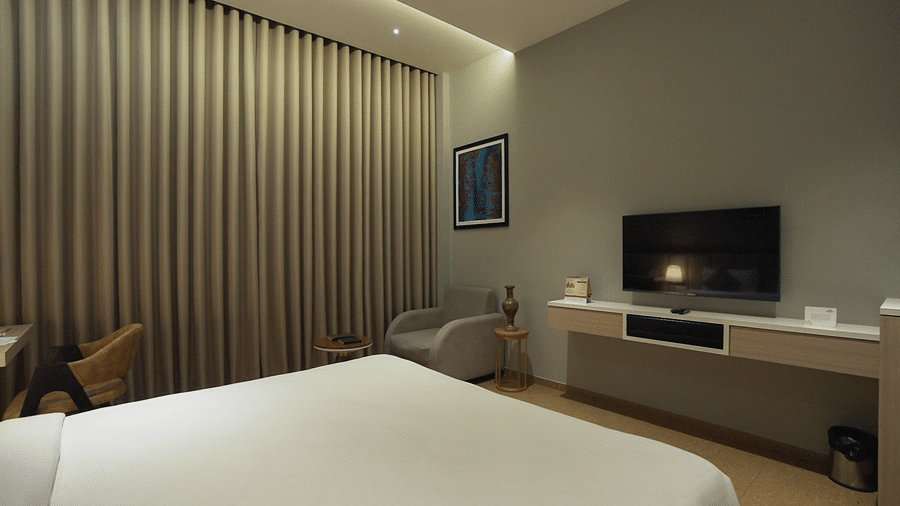 Close up view shot of Superior Room featuring a comfortable double bed with pillows and cushions arranged over it - Pride Resort, Rajkot