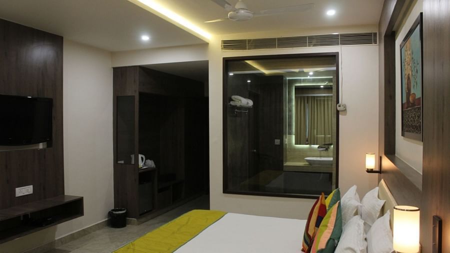 Interior view of a room with dark wood furniture, a flat-screen TV, and a bathroom with a mirror.