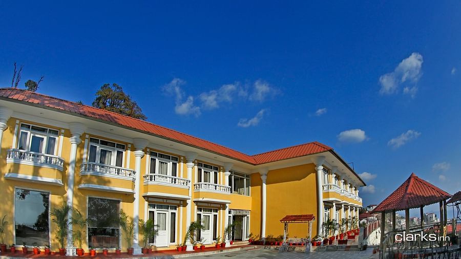 Facade of Starz Clarks Inn in Mussoorie under clear blue sky