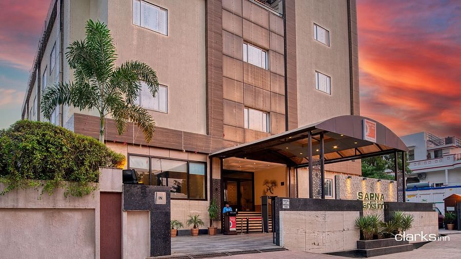 Facade of Sapna Clarks Inn in Lucknow with a vibrant evening sky in the background