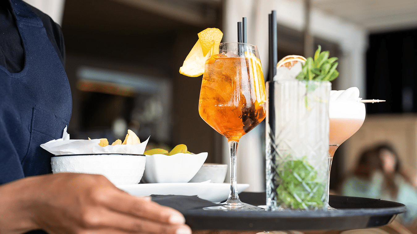 A waiter carrying a tray of delicious drinks and finger bites - S Hotels, Jamaica