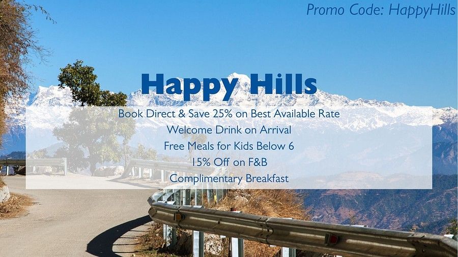 An advertisement for Happy Hills with a background image of a snowy mountain range and a road with a guardrail. The text advertises booking discounts, a welcome drink, free meals for kids, F&B discounts, and complimentary breakfast, and includes a promo co