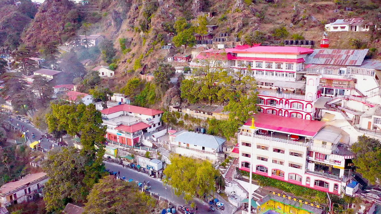 Aerial view of Mussoorie with buildings and trees around it.