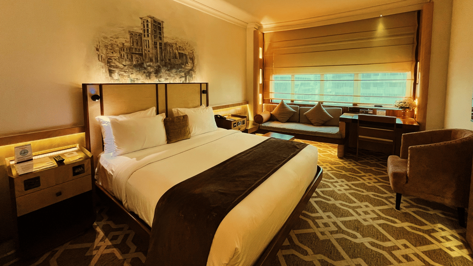 Hotel room with bed, sofa, and window view at Marco Polo Hotel.