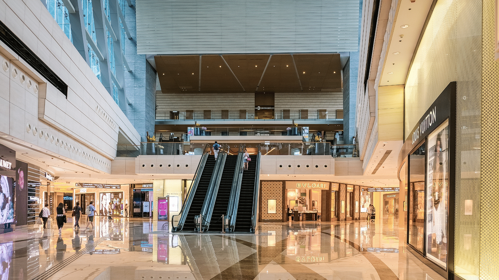 overview of A shopping mall with escalators in the centre and shops behind it near Rhythm Gurugram