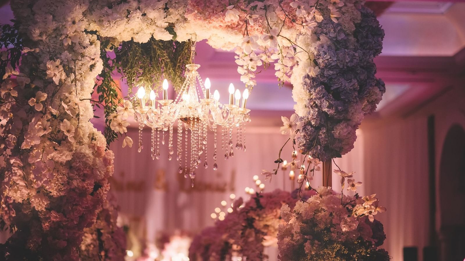 A flowery wedding decoration with a chandelier inside one of the banquet halls at Rhythm Gurugram.