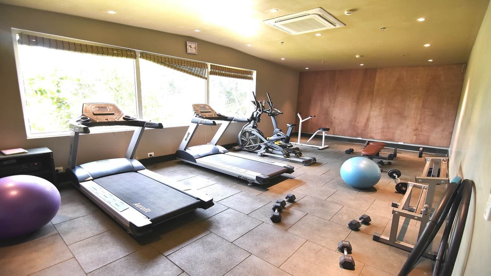 Health club at Swosti Chilika Resort with treadmill and dumbbells
