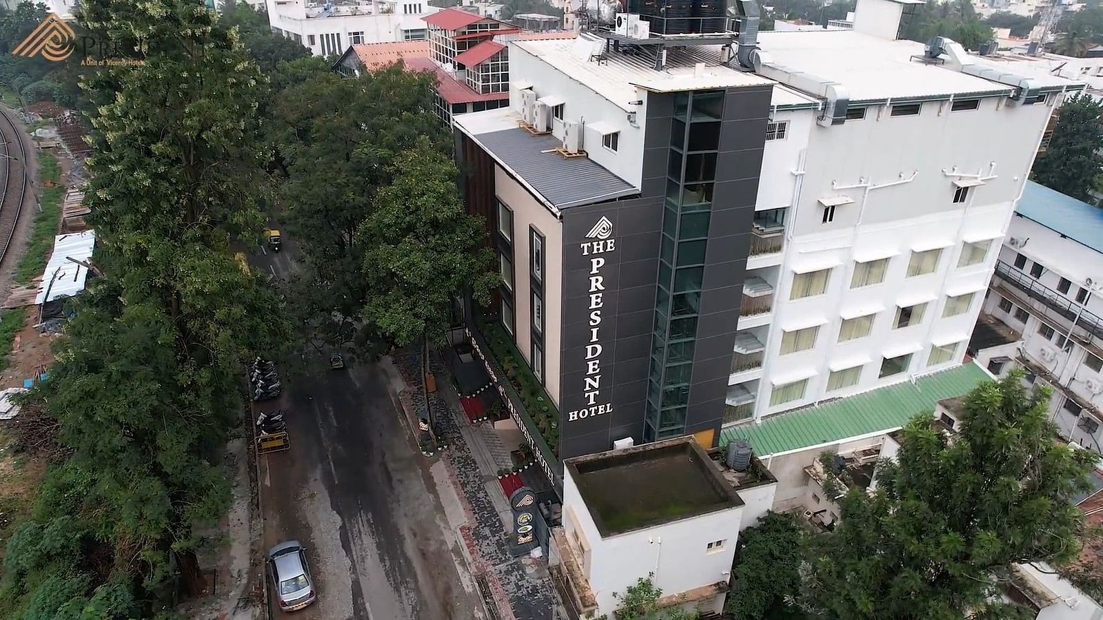 An image of aerial view of a modern hotel building amidst an urban landscape - The President Hotel, Kumara Park, Bangalore