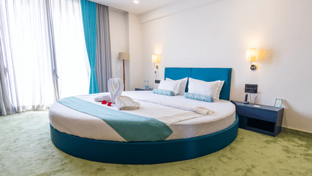 This modern bedroom includes a unique round bed and large windows that let in plenty of natural light.