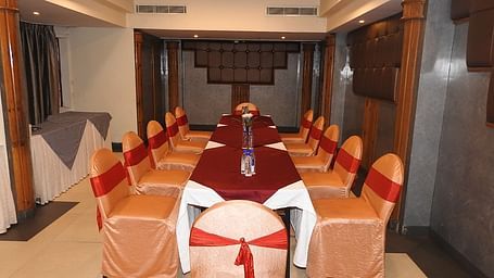 Image of Royal Room with a long table and chairs arranged around it at Swosti Grand, Bhubaneswar