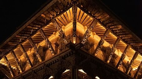 The carvings on a temple structure which is brightly lit