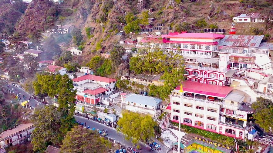 Aerial view of Mussoorie with buildings and trees around it.