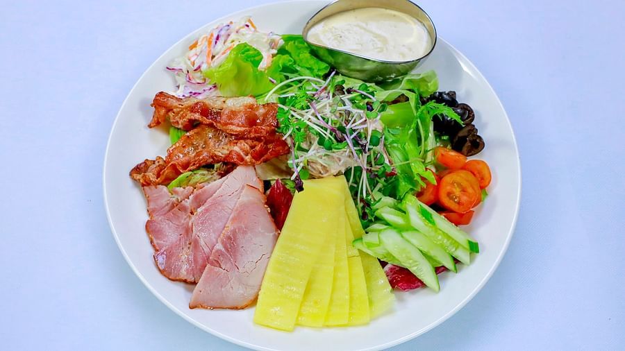 A plate with a variety of food items, including meat, vegetables, and dressing | The Shop | Central Mansions, Phnom Penh
