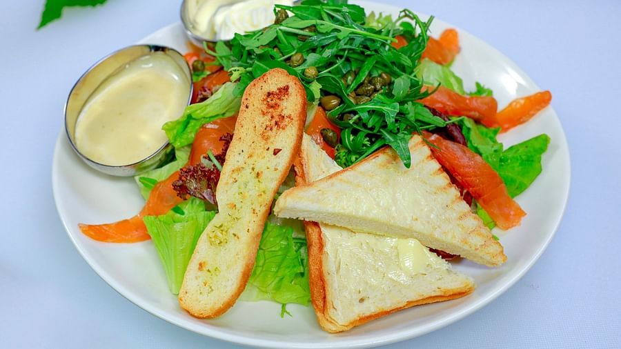 A plate of salad with bread, dressing, and various vegetables | The Shop | Central Mansions, Phnom Penh