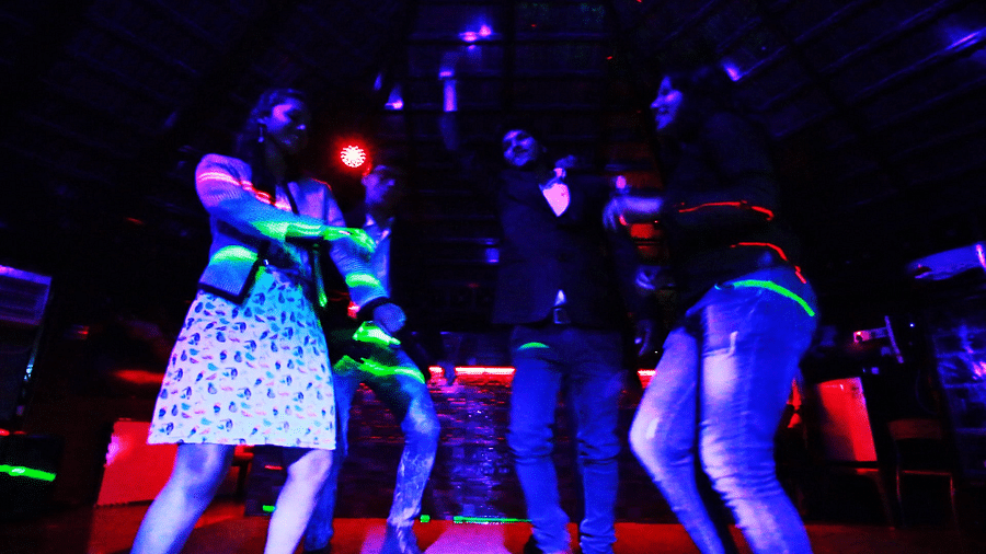 Image of a group of people dancing with disco lights beaming on them at Coorg Jungle Camp Backwater Resort, Kushalnagar.