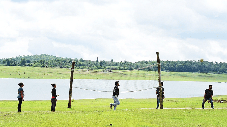 Image of a group of people playing volleyball beside a water body at Coorg Jungle Camp Backwater Resort, Kushalnagar.
